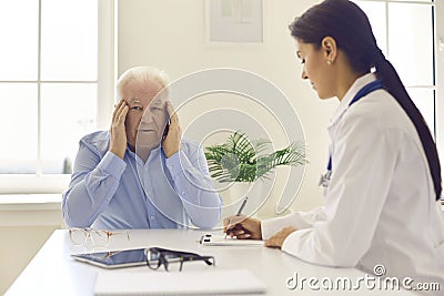 Senior man complaining about headache, stress or blurred eyesight during medical interview Stock Photo