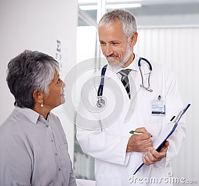 Senior man doctor with patient, clipboard for information and medical forms during consultation. Healthcare, old woman Stock Photo