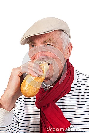 Senior man eating French bread Stock Photo