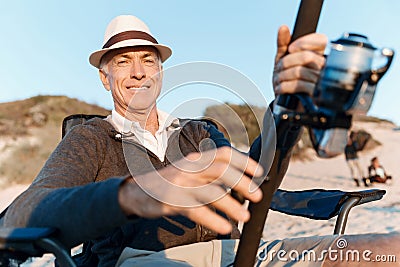 Senior man fishing at sea side Stock Photo