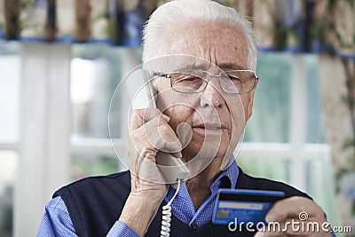 Senior Man Giving Credit Card Details On The Phone Stock Photo