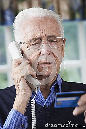 Senior Man Giving Credit Card Details On The Phone Stock Photo