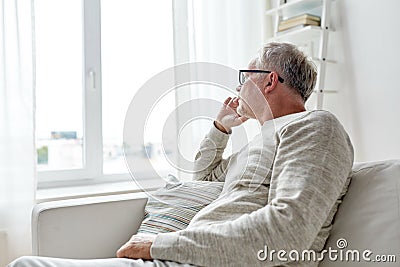 Senior man in glasses thinking at home Stock Photo