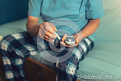 Senior man with glucometer checking blood sugar level Stock Photo