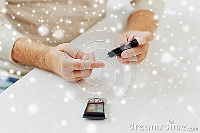 Senior man with glucometer checking blood sugar Stock Photo