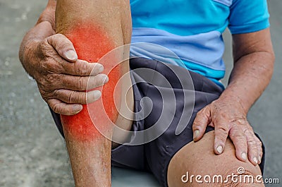 Senior man hand holding foot and massaging ankle in pain area. Stock Photo