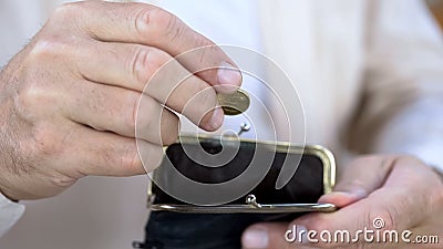 Senior man hand putting cent coin in wallet, money saving, retirement and budget Stock Photo