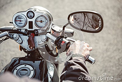 Senior man hand steering motorcycle on road Stock Photo