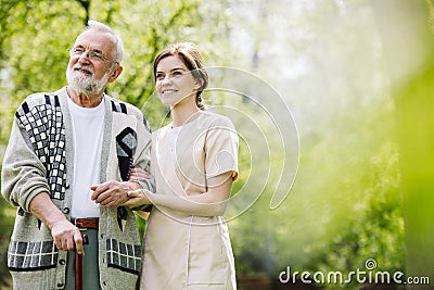 man with helpful volunteer in the garden of professional care home Stock Photo