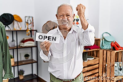 Senior man holding banner with open text at retail shop annoyed and frustrated shouting with anger, yelling crazy with anger and Stock Photo