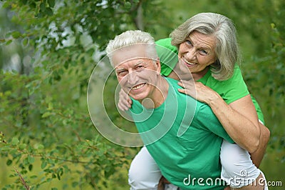 Senior man hugging senior woman in forest Stock Photo