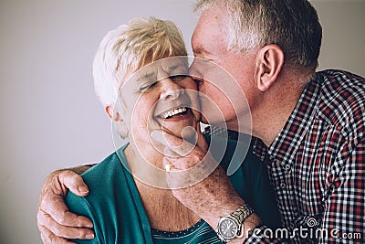 Senior man kissing wife on cheek Stock Photo