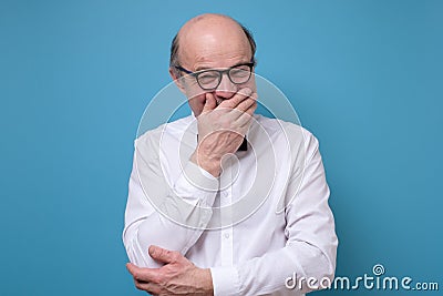 Senior man laughing and embarrassed giggle covering mouth with hands Stock Photo