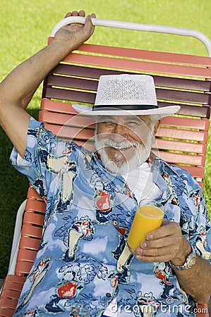 Senior Man lying on lawn chair Stock Photo