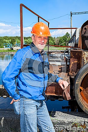 Senior man mechanist stands near sewage treatment plant Stock Photo