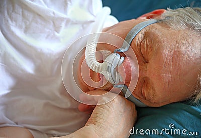 Man with sleep apnea uses breathing device Stock Photo
