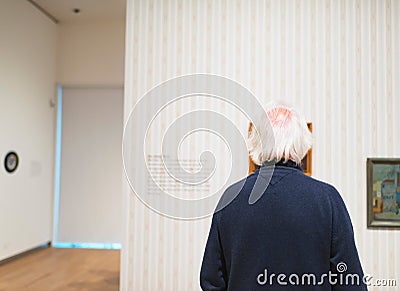 Senior man observing artwork in museum room. Editorial Stock Photo