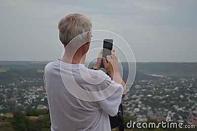 Senior man photographs on the phone a view of the city. Pyatigorsk, Russia Editorial Stock Photo