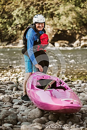 Senior man preparing for kayak tour on a mountain river Stock Photo