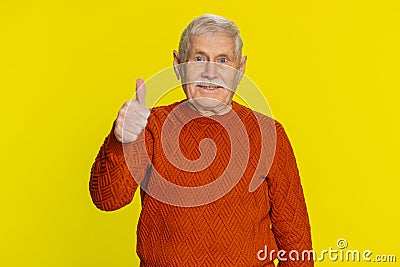 Senior man raises thumbs up agrees or gives positive reply recommends advertisement likes good idea Stock Photo
