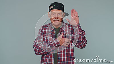 Senior man raising hand to take oath, promising to be honest and to tell truth keeping hand on heart Stock Photo