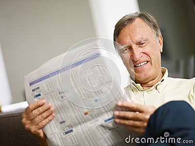 Senior man reading stock listings Stock Photo