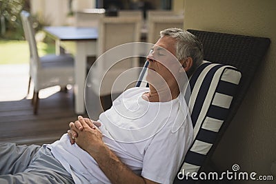 Senior man resting on lounge chair Stock Photo