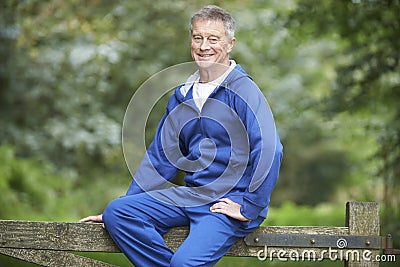 Senior Man Resting Whilst Exercising In Countryside Stock Photo