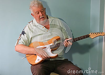 Senior man playing guitar and singing. Stock Photo