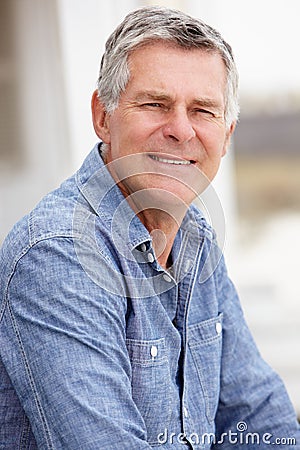 Senior man sitting outdoors Stock Photo