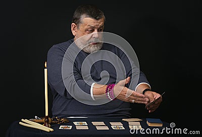 Senior man soothsayer showing which card falls Stock Photo