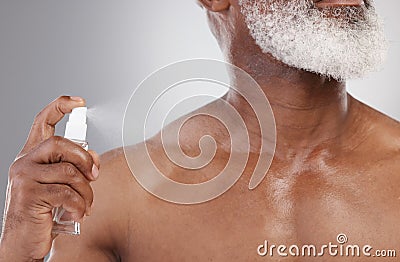 Senior man with spray bottle, cologne and grooming with beauty and cosmetic fragrance isolated on studio background Stock Photo