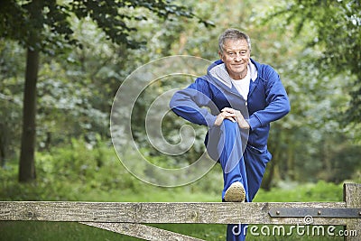 Senior Man Stretching On Countryside Run Stock Photo