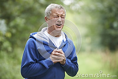 Senior Man Suffering Heart Attack Whilst Jogging Stock Photo