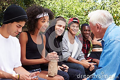 Senior Man Talking With Gang Of Young People Stock Photo