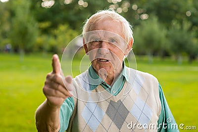 Senior man threatens with finger. Stock Photo