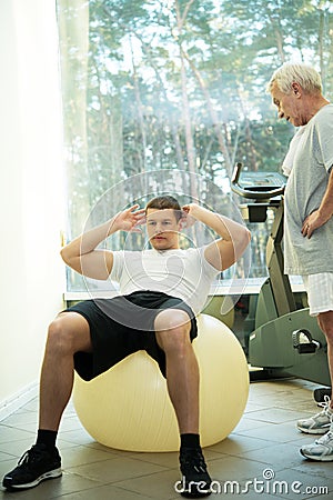 Senior man and trainer in a fitness club Stock Photo