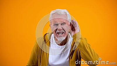 Senior man trying to hear interlocutor, health problems of aged people, deafness Stock Photo