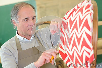 Senior man upholstering chair in workshop Stock Photo