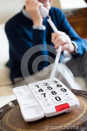 Close Up Of Senior Man Using Telephone With Oversized Keypad At Stock Photo