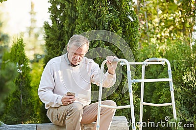 Senior Man with Walker Resting in Park Stock Photo