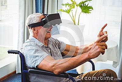 Senior man in a wheelchair using a virtual reality device Stock Photo