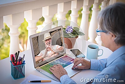 Senior man and woman away due to lockdown for coronavirus in videochat from laptop - man making heart shape with hands - elderly Stock Photo