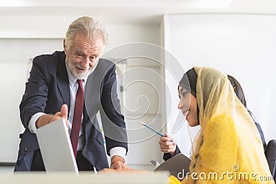 Senior manager training young intern trainee to use application in computer Stock Photo
