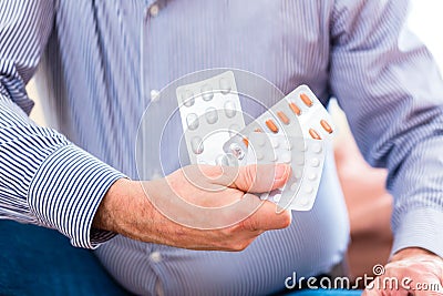 Senior medicate with pills at home Stock Photo