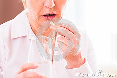 Senior medicate with pills at home Stock Photo