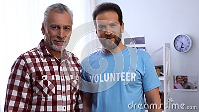 Senior man and social worker looking at camera, charity organization, caregiver Stock Photo