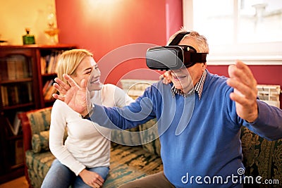 Senior man using virtual reality simulator and having fun with n Stock Photo