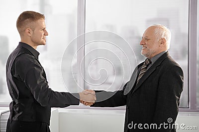 Senior and mid-adult businessman shaking hands Stock Photo