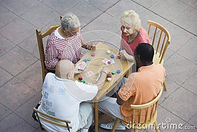 Senior Multiethnic Friends Playing Cards Together Stock Photo